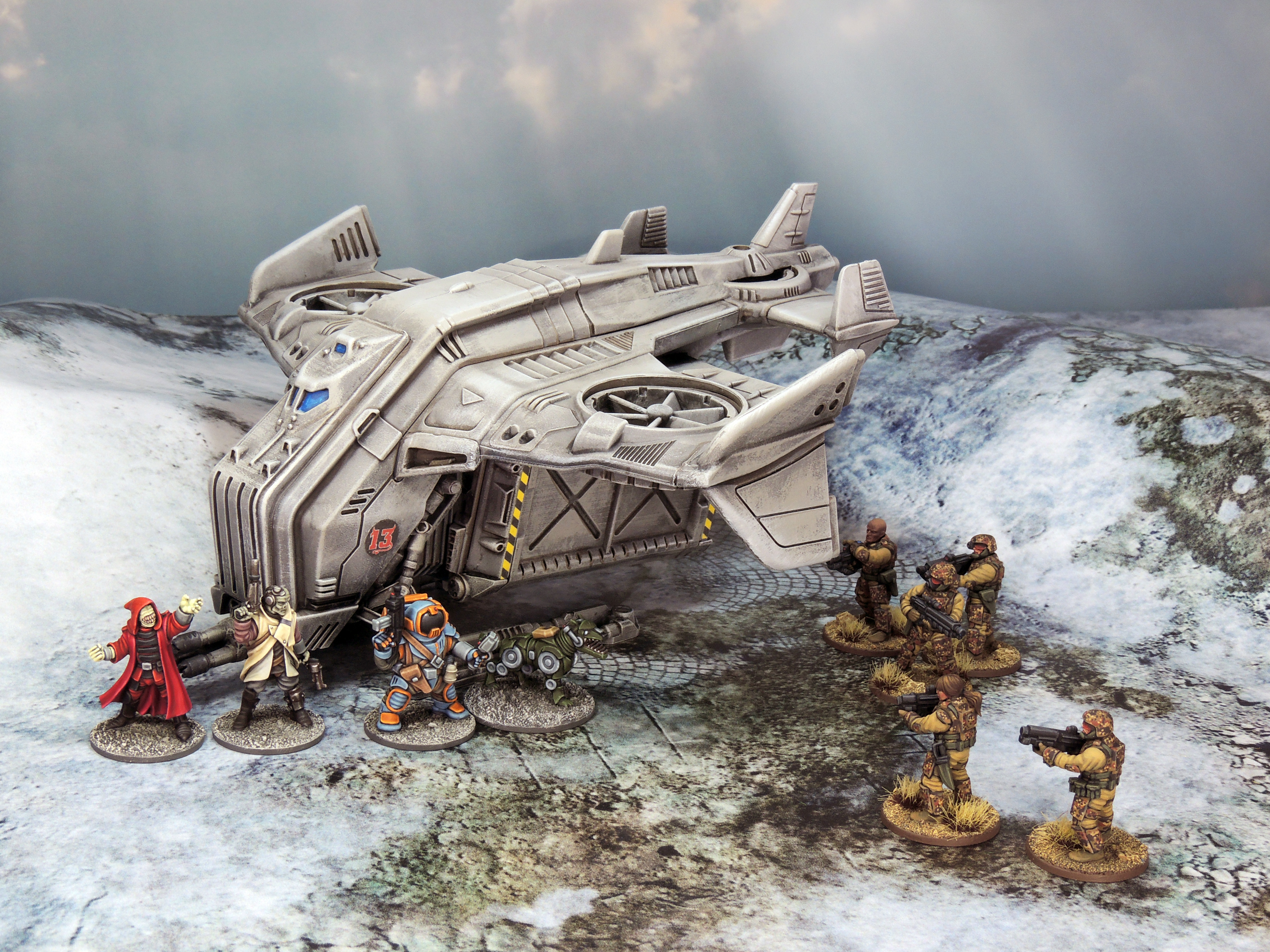 A photograph of miniature figures depicting a stand-off between two groups in front of a landed spacecraft in a snowy environment